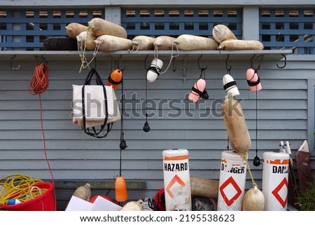 Equipment and other related stuff on the side of a boathouse at a lake Royalty-Free Stock Photo #2195538623