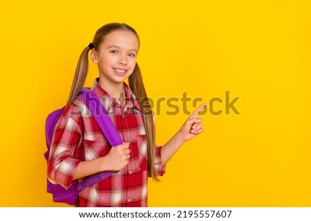 Photo of adorable funny schoolkid dressed plaid shirt pointing empty space isolated yellow color background