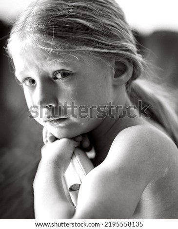 Black and white photo. Kerupny plan, a look at the camera. The girl is crying, tears are pouring from her eyes, her long hair is pulled back in a ponytail, her hands are bare