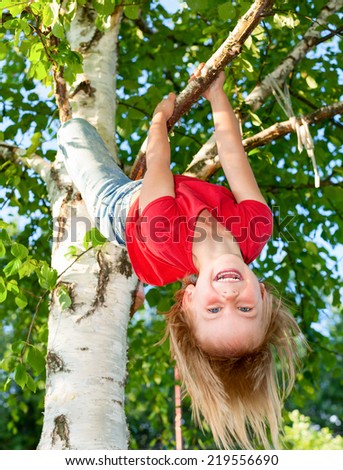 Little girl having fun playing on birch tree Royalty-Free Stock Photo #219556690