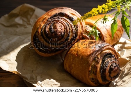 Bun with poppy seeds on an old background