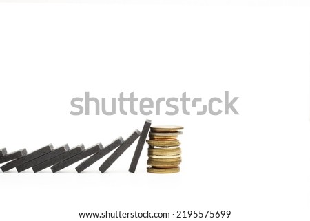 Black wooden blocks and a heap of coins on a white background with copy space