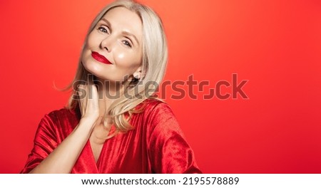 Portrait of attractive elder woman, happy mature lady with beautiful blond hair, no wrinkles and clear facial skin, laughing with closed eyes, smiling on christmas or new year, winter holidays Royalty-Free Stock Photo #2195578889