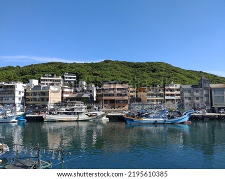The view of fishing boat parking at the harbor with blue sky in Chang-Tan Fishing Harbor in Keelung in Taiwan. The letters and numbers printed on the boat means theirs name.