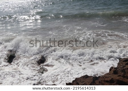 Moroccan atlantic coast with the sea waves foam on a summer day.  Region of Agadir in Morocco.