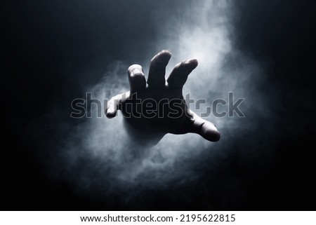 Human hand on dark background Royalty-Free Stock Photo #2195622815