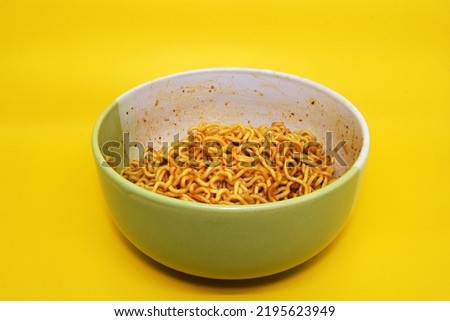 Photo of instant noodles in a bowl on a yellow background