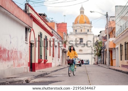 Young woman on a bicycle. Beautiful Hispanic teen riding a bike in Guatemalan neighborhood . Royalty-Free Stock Photo #2195634467