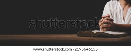 Close up of Asian christian woman person pray and worship for thank god in church with black background, The concept for faith, spirituality and religion, horizontal banner.