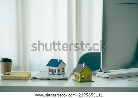 Real estate sales office with example of a house on a businessman's desk.