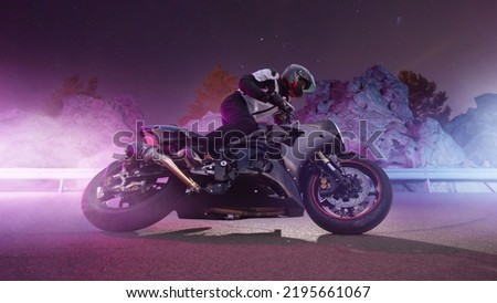 Moto rider making a stunt on his motorbike. Motorcycle stunt riding. Royalty-Free Stock Photo #2195661067