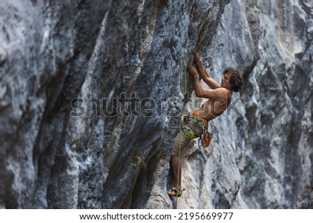 rock climber climbs the rock. a strong man overcomes a difficult route. relaxation and freedom in nature.