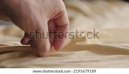 man touching yellow cotton clothes closeup, wide photo