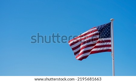 Image with American flag with clear blue sky.