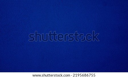 Abstract navy blue cement wall background.
Ultramarine color paint surface grain concrete texture.
