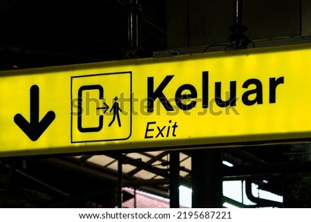 Yellow background exit sign "KELUAR" at a train station (Indonesian for "EXIT")