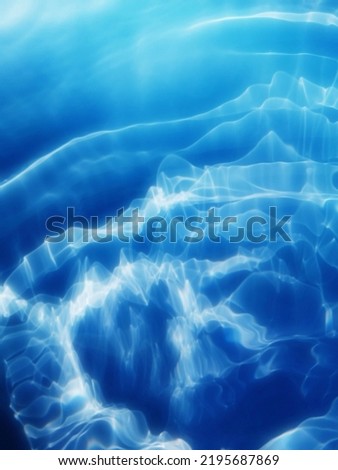 Closeup​ blur​red​ abstract​ of​ surface​ blue​ water. Abstract​ of​ surface​ blue​ water​ reflected​ with​ sunlight​ for​ background.Top​ view​ of blue​ water.​ Water​ splashed for​ background. 