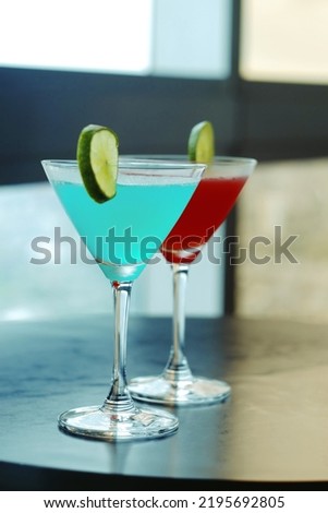 close up glass of blue and red cocktail with lemon slice on table, food and drink business, relaxation and lifestyle concept