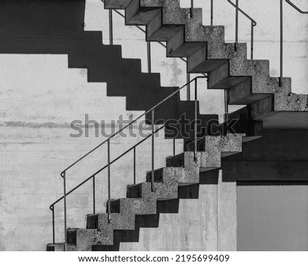 Abstract architecture background, square concrete stairway perspective, stairwell, black and white photo. Minimalism architecture. Modern architecture with distinguishing shades of black and white.