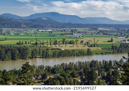 View of the Fraser Valley near Abbotsford BC. Summer in the Fraser Valley. Canadian homestead. Rural agricultural land. The Frazier River is an important salmon habitat for the lower mainland of BC Royalty-Free Stock Photo #2195699527