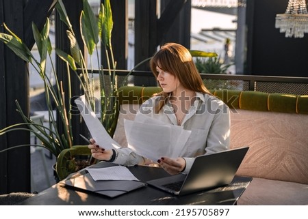 Shot of busy woman executive with papers and laptop working in modern corporation office.