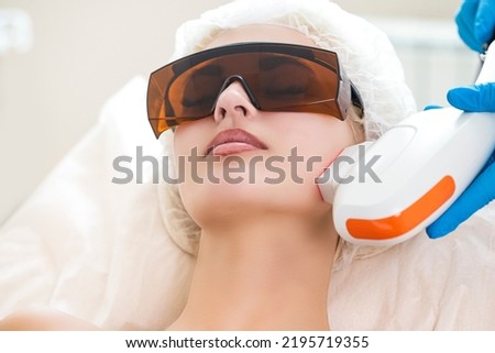 Young Caucasian Winsome Woman Getting IPL Laser and Ultrasound Facial Treatment in Modern Medical Spa Center As Skin Rejuvenation.Horizontal image Royalty-Free Stock Photo #2195719355