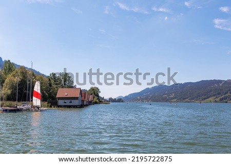 Colorful wooden boathouses with jetty at the Alpsee near Immenstadt Royalty-Free Stock Photo #2195722875