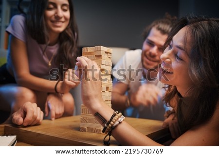 Group of young people spending time together at home, they are playing Jenga Royalty-Free Stock Photo #2195730769