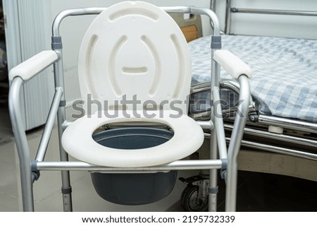 Flush toilet and shower chair in bathroom for old elder people.