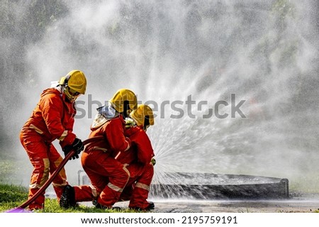 Firefighters, Firemen spraying high pressure water or suitable extinguishing agents to fire.fire fighter Using Twirl water mist fire extinguishers to fight oil flames to control fires from spreading. Royalty-Free Stock Photo #2195759191