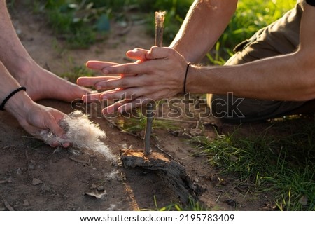 Fire making in the wild (wilderness survival). Hand-drill fire method. Closeup. Royalty-Free Stock Photo #2195783409