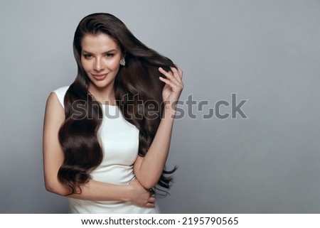 Posing woman brunette. Young smiling woman with perfect hairstyle wearing gold earring on white banner background Royalty-Free Stock Photo #2195790565