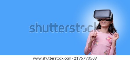 VR glasses,, little girl with virtual reality headset. Innovation technology and education concept. Funny girl using a virtual reality headset isolated on blue  background