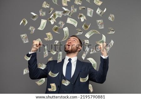 Happy business man very rich guy with money dollar bills in air like rain. Business success concept