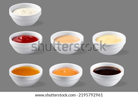 On a gray background in white bowls are mango, chili, mayonnaise, cheese, ketchup, jack daniels, barbecue sauces.