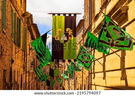 colorful banners hanging from ancient stone buildings during the traditional palio in Citta'della Pieve, Umbria