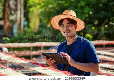 Portrait happy indigenous young Asian man SME business owner working use digital tablet for e-commerce or business online. Incense sticks SME business. Southeast asia culture and tourism. Royalty-Free Stock Photo #2195803349