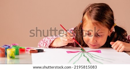 Portrait of beautiful child girl painting the picture. Art and education concept. Copy space.