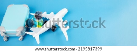 cheap air tickets online banner, low-cost airlines, international flights, plane, suitcase for luggage, sunglasses on a blue background