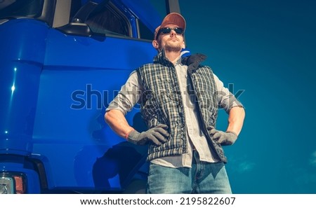 Proud Caucasian Semi Truck Driver in His 40s in Front of His Modern Vehicle. Heavy Duty Transportation Industry Theme. Royalty-Free Stock Photo #2195822607