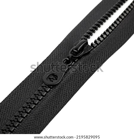 Unzip zipper or fastener. Closeup of a cloth zipper under the lights with. Open zipper isolated on white background. Royalty-Free Stock Photo #2195829095