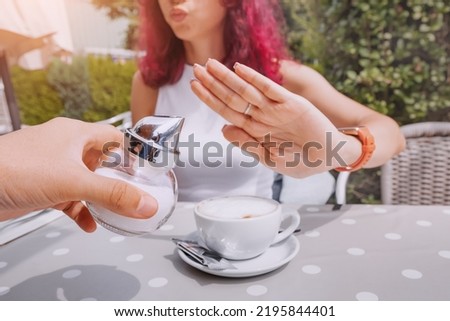 The girl is on a healthy diet and refuses to add sugar to her coffee. The concept of diseases from an excess of fast carbohydrates and diabetes Royalty-Free Stock Photo #2195844401