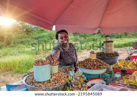 african street vendor selling peanuts, mopane worms and lollipops on the streets of the town