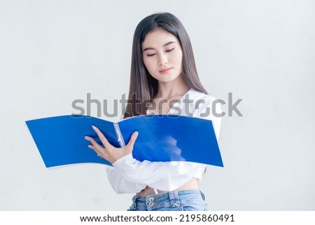 A beautiful graphic designer reviewing some draft pencil sketches on a blue sketchpad. Isolated on a white background.