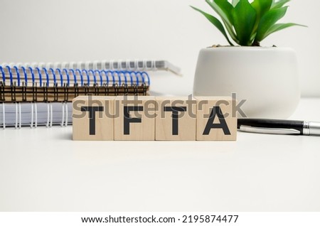 TFTA - Tripartite Free Trade Area acronym on wooden blocks and notepads