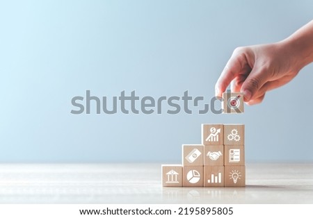 Hand arranging wood block stacking with business strategy and Action plan,targeting the business concept.business development concept. Royalty-Free Stock Photo #2195895805