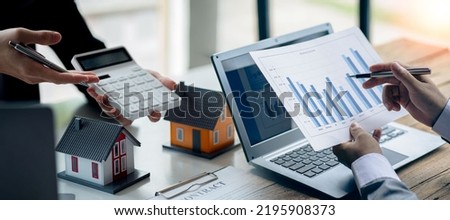 Real estate business concept A rental company employee is calculating the cost for the customer to agree to sign a title contract by explaining the terms and conditions of sale. Royalty-Free Stock Photo #2195908373