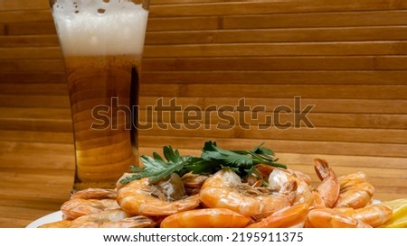 Shrimp boiled in a shell, a glass of beer. Seafood. Background picture. Space for printing text.