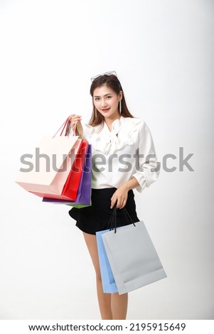 Portrait of an excited beautiful woman holding shopping bags isolated on white background.