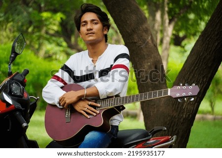 boy with red guitar with red biike
